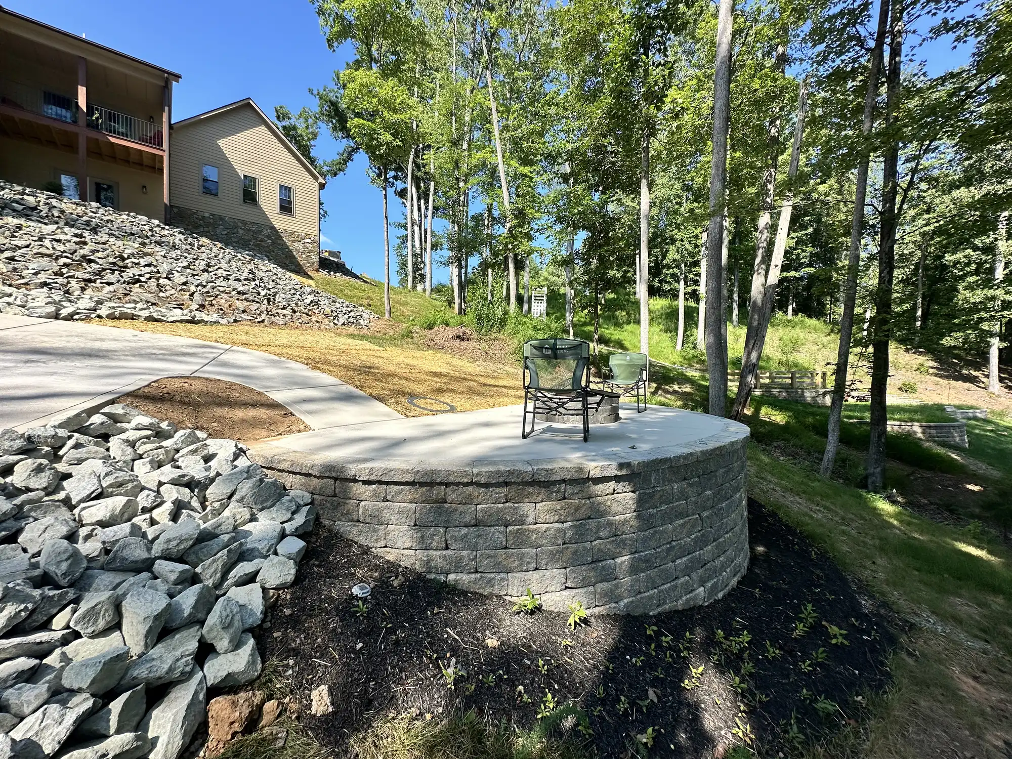 Fire pit with concrete pad and stone hardscaping at Smith Mountain Lake