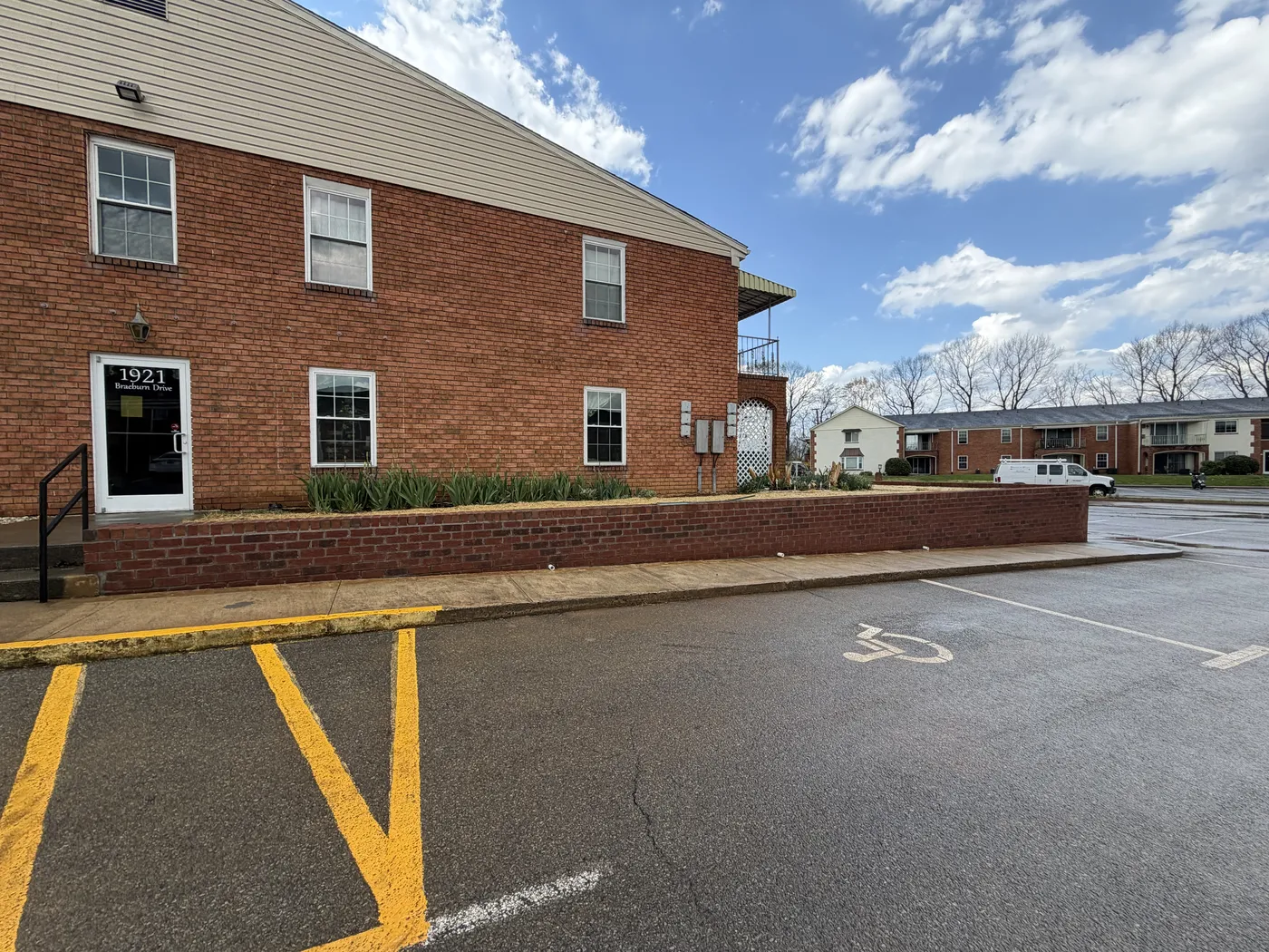 Brick retaining wall with planter beds at apartment entrance