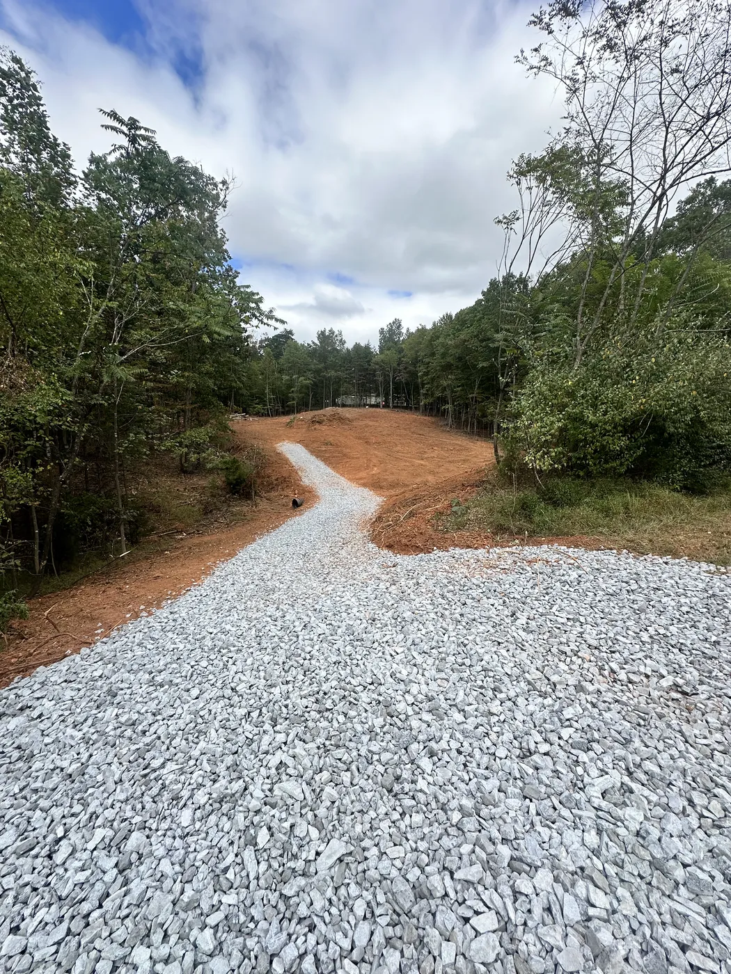 Cleared wooded property with gravel driveway for barndominium site at Cinnamon Ridge